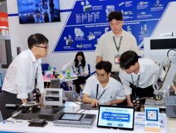 Sinh viên thực tập thao tác kỹ thuật với cánh tay robot tại triển lãm VIMF Bình Dương 2025.